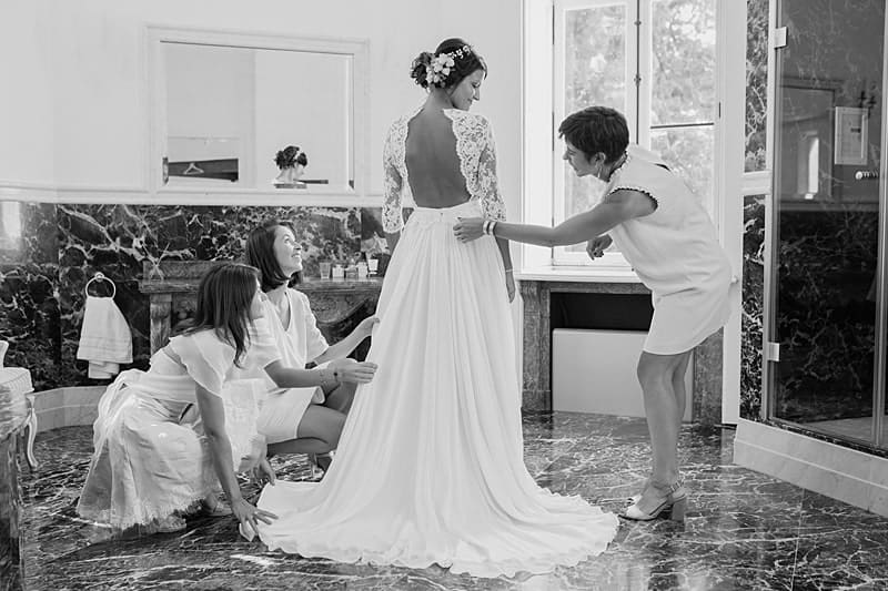 Les demoiselles d'honneur ajustent la robe de la mariée