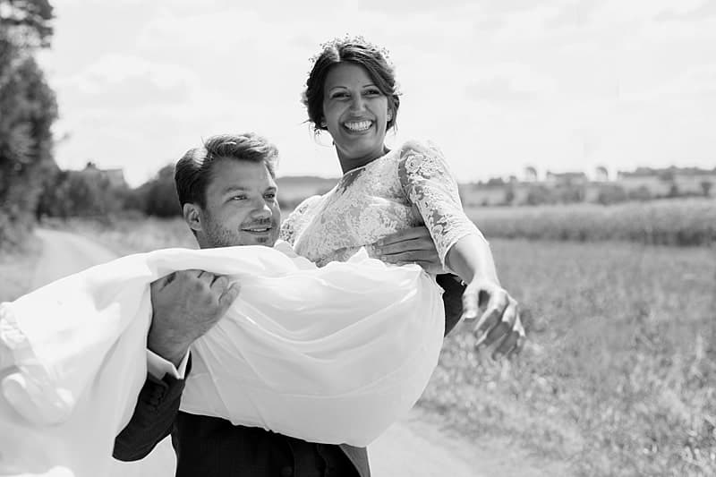 Le marié porte la mariée ravie