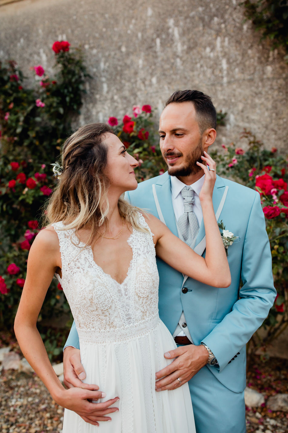 la mariée tient le visage du marié