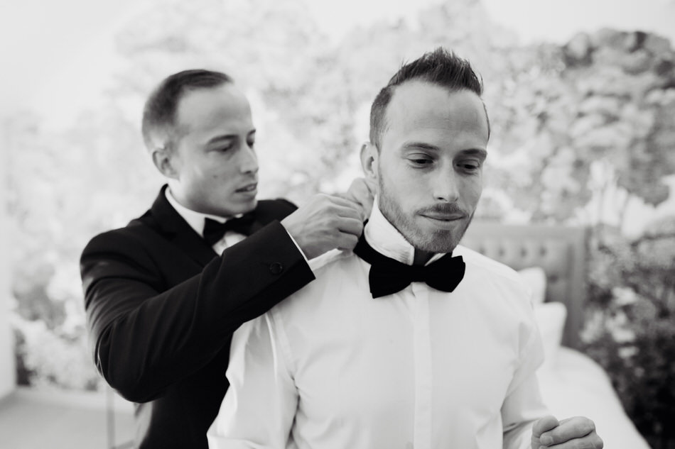 Le marié se fait aider pour mettre son nœud papillon