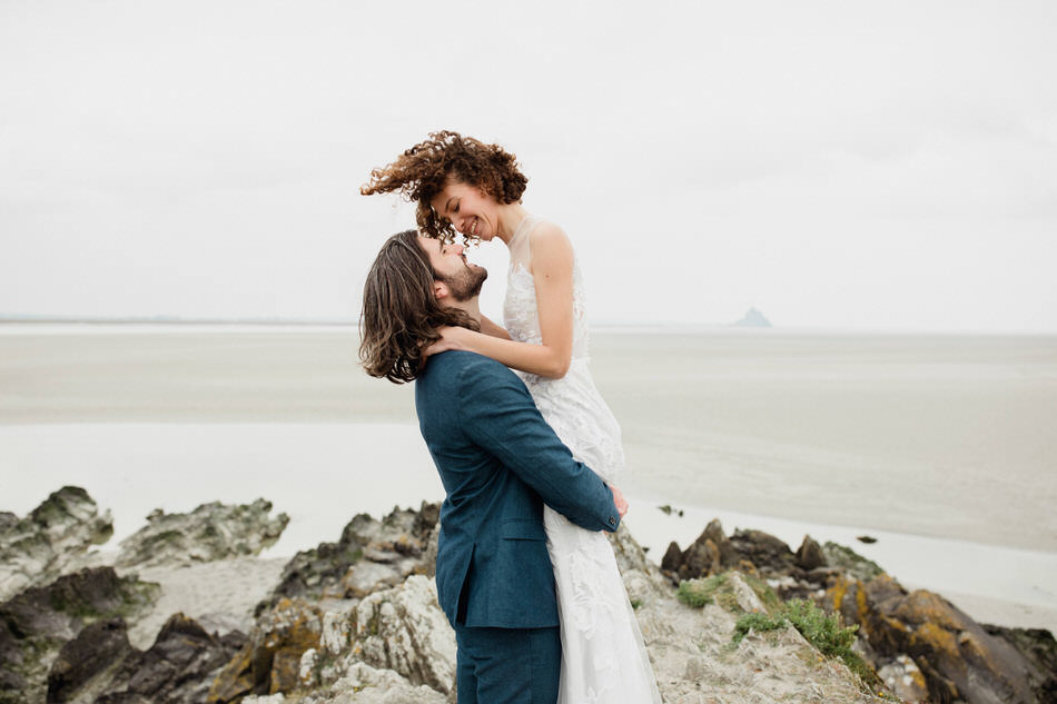 Le marié tient la mariée dans ses bras