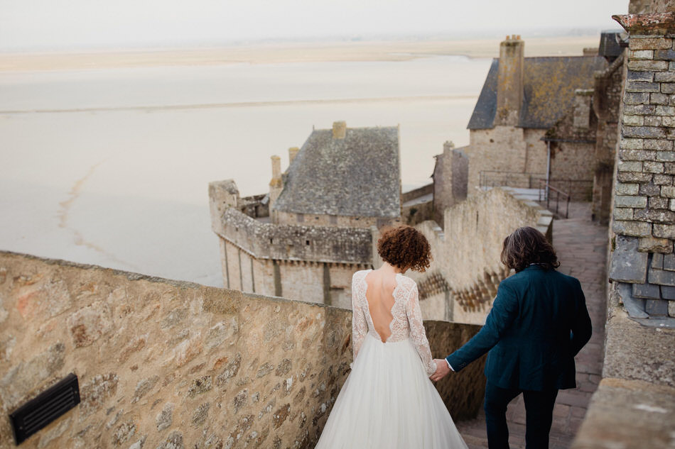 Les mariés main dans la main dans les rues du mont st michel