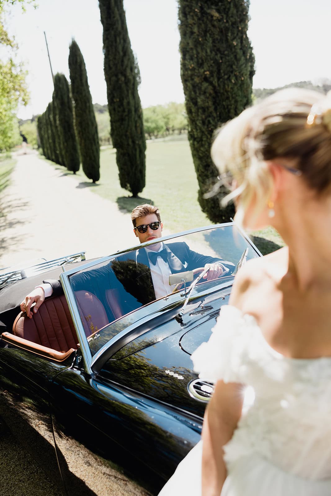The bride look at the groom in the car.