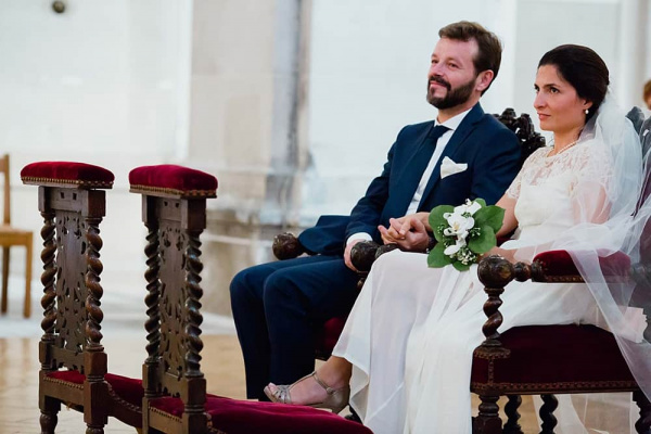 Les mariés écoutent attentivement la bénédiction du prêtre Couple de mariés à l'église