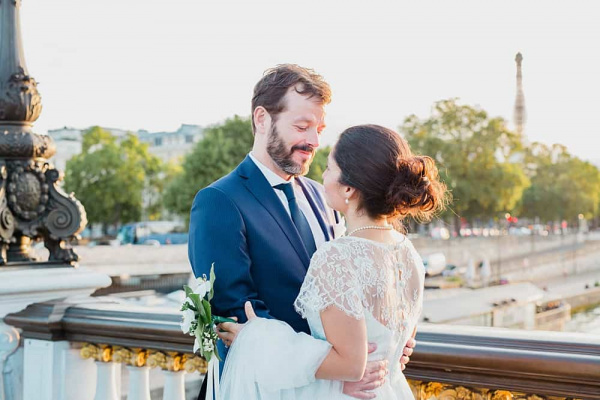 La Tour Eiffel en arrière plan, les mariés se regardent amoureusement Mariage sur le Pont Alexandre III à Paris