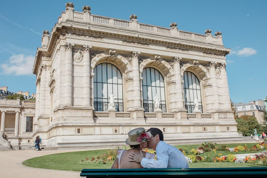 les époux s'embrassent sur un banc parisien